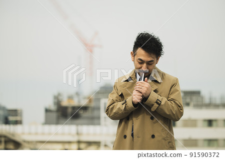 A bearded man in a trench coat that looks like a police drama 91590372