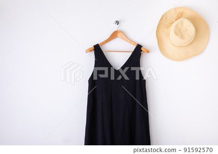 One piece and straw hat hung on a white wall One piece and straw hat hung on a white wall 91592570