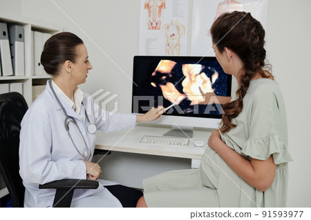 Gynecologist discussing baby scan with patient Gynecologist discussing baby scan with patient 91593977