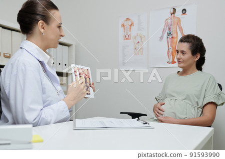 Doctor presenting information to pregnant woman Doctor presenting information to pregnant woman 91593990