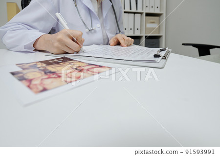 Doctor filling medical card at office 91593991