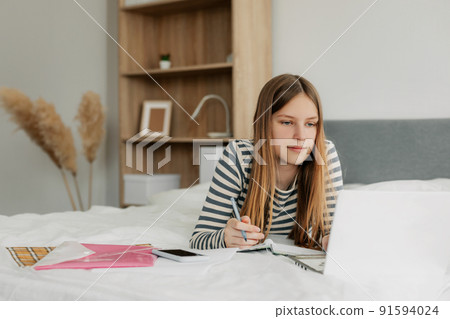 Portrait of a cute girl student preparing for lectures using a laptop. The concept of training and education, modern technologies 91594024