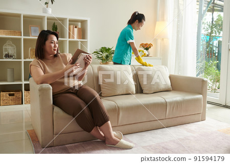 Woman using cleaning service to clean apartment 91594179