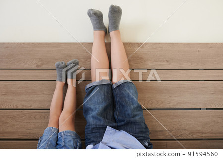 Brothers Holding Legs up on Wall 91594560