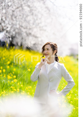 Portrait of a business woman surrounded by cherry blossoms and rape blossoms Portrait of a business woman surrounded by cherry blossoms and rape blossoms 91594660