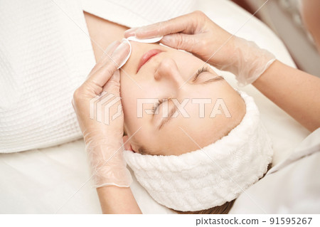 Face massage at luxury spa salon. Cottom pad. Remove mascara. Doctor hands 91595267