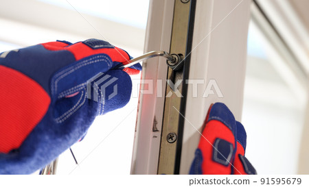 Master in gloves adjusting locks of pvc windows with special key Master in gloves adjusting locks of pvc windows with special key 91595679