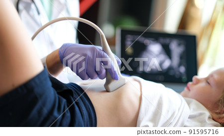 Doctor examining with ultrasound of internal organs of child in clinic 91595716