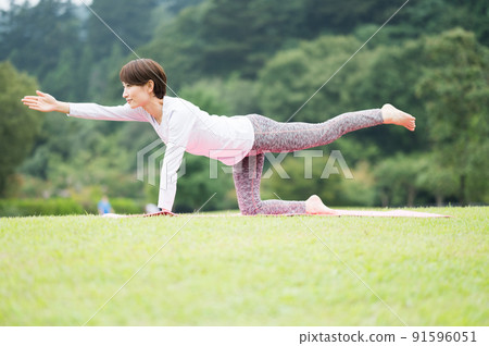 中間女人在公園裡做瑜伽姿勢 91596051