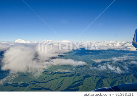 View the mountains of the Northern Alps from an airplane under cloudy weather Matsumoto City, Nagano Prefecture, from between the clouds 91598121