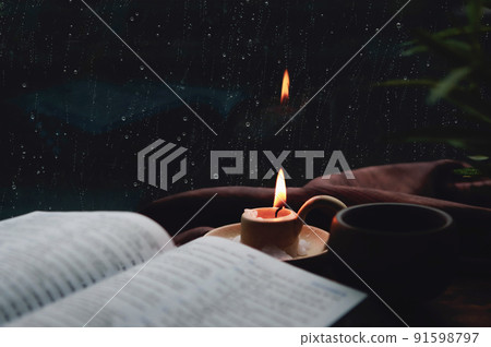 Rain and raindrops falling on the window, candles, crosses and bibles 91598797