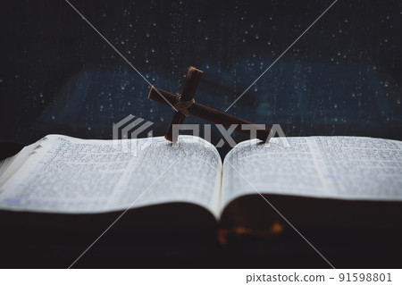 Rain falling on the window and flowing raindrops, cross and bible Rain falling on the window and flowing raindrops, cross and bible 91598801