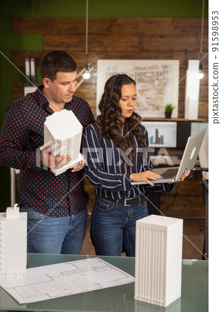 Caucasian male and female architects working on 3D printed models. Caucasian male and female architects working on 3D printed models. 91598953