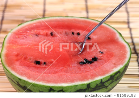 Watermelon and spoon cut in half 91599198