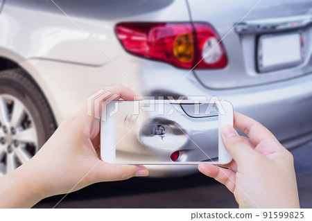 woman using mobile smartphone taking photo of car accident damaged for insurance 91599825