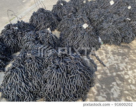 Round link chains for conveying and elevating equipment are folded in heaps. A lot of steel chains stacks Round link chains for conveying and elevating equipment are folded in heaps. A lot of steel chains stacks 91600202
