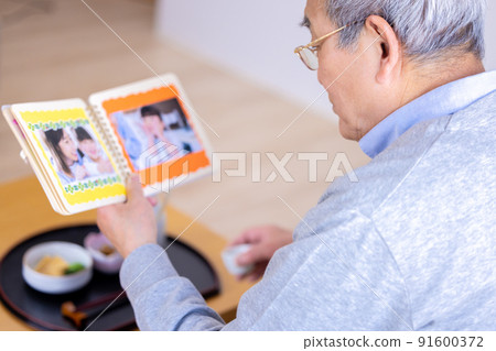 爺爺一邊喝酒一邊看著孫子的照片 91600372