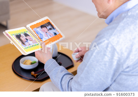 爺爺一邊喝酒一邊看著孫子的照片 91600373