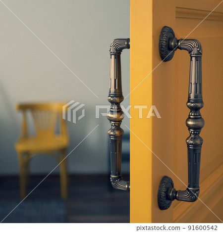 Pull handles on rose. Back to back pull handles, close up. House interior door is ajar Pull handles on rose. Back to back pull handles, close up. House interior door is ajar 91600542