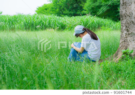 低頭在草地上的女孩 91601744