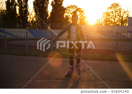Girl riding roller skates in the park 91604140