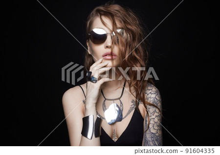 Beautiful sexy woman with tattoo. tattooed girl in sunglasses and jewelry. cheerful model 91604335