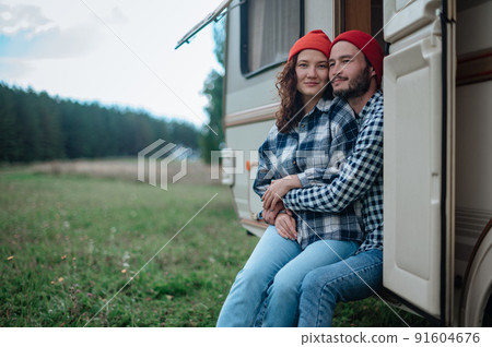 Romantic couple spending time together near trailer home. 91604676