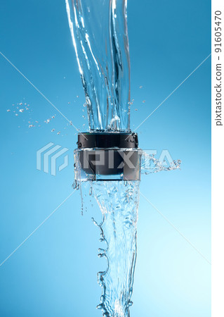 Front view of flying cosmetic jar with water splash in surface with blue background  91605470