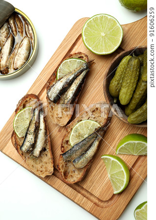 Board with sandwiches with sprats on white background 91606259