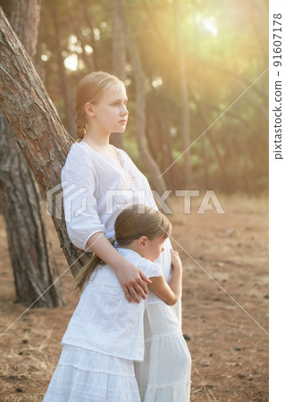 Sisters hugging on nature and sunlight background 91607178