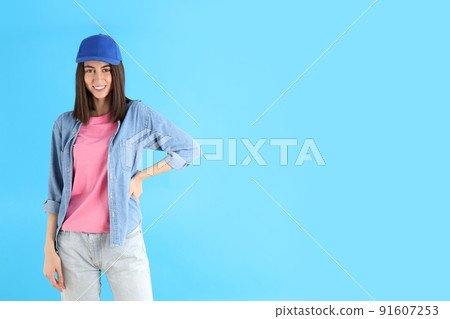 Attractive girl in cap on blue background 91607253