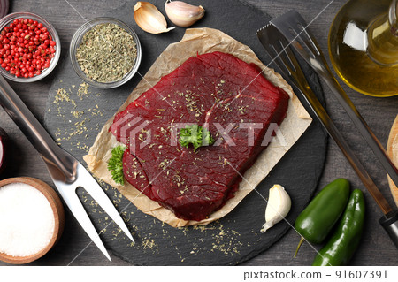 Concept of cooking with raw beef steak on dark wooden background 91607391