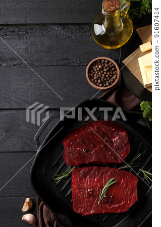 Concept of cooking with raw beef steaks on dark wooden table Concept of cooking with raw beef steaks on dark wooden table 91607414