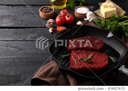 Concept of cooking with raw beef steaks on dark wooden table 91607415