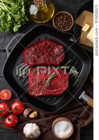 Concept of cooking with raw steak on wooden background Concept of cooking with raw steak on wooden background 91608623