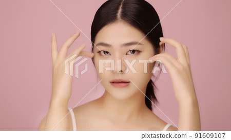 Close up face of beautiful young Asian woman with clear skin lifting eyes with finger on pink background. Close up face of beautiful young Asian woman with clear skin lifting eyes with finger on pink background. 91609107