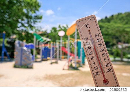 A thermometer with an outside temperature of 36 ° C and park playset on a hot day 91609285