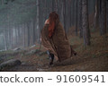 Young red-haired girl in medieval knight's armor in summer forest 91609541