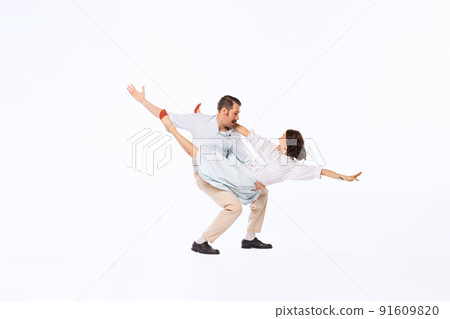 Portrait of young beautiful couple, man and woman, dancing twist isolated over white studio background Portrait of young beautiful couple, man and woman, dancing twist isolated over white studio background 91609820