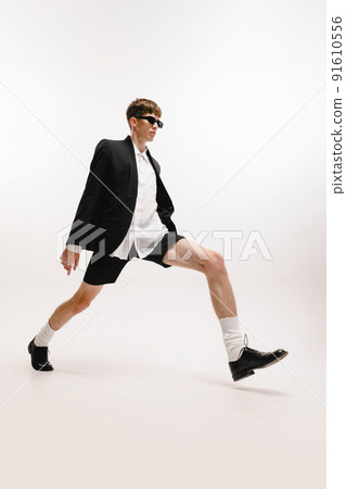 One young stylish man, student in black shorts and jacket posing isolated over white background. Concept of fashion, youth, emotions, studying, ad One young stylish man, student in black shorts and jacket posing isolated over white background. Concept of fashion, youth, emotions, studying, ad 91610556
