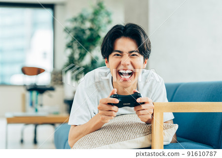 Young man playing games in the living room 91610787