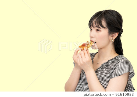 A woman eating pizza deliciously 91610988