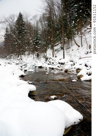 A small active waterfall. Clean mountain stream, snowy winter landscape, wildlife background A small active waterfall. Clean mountain stream, snowy winter landscape, wildlife background 91611152