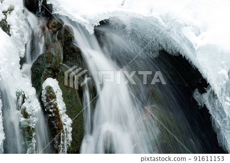 A small active waterfall. Clean mountain stream, snowy winter landscape, wildlife background A small active waterfall. Clean mountain stream, snowy winter landscape, wildlife background 91611153