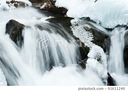 A small active waterfall. Clean mountain stream, snowy winter landscape, wildlife background A small active waterfall. Clean mountain stream, snowy winter landscape, wildlife background 91611240
