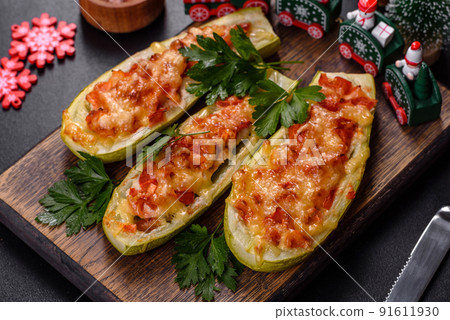 Baked stuffed zucchini boats with minced chicken mushrooms and vegetables with cheese. Christmas table Baked stuffed zucchini boats with minced chicken mushrooms and vegetables with cheese. Christmas table 91611930