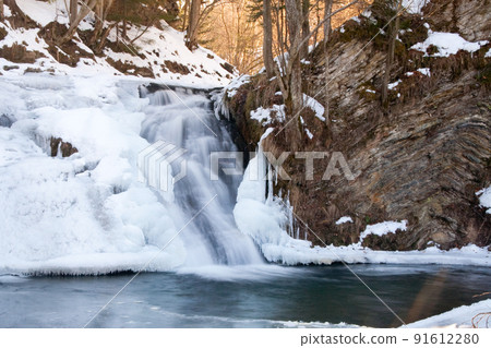 A small active waterfall. Clean mountain stream, snowy winter landscape, wildlife background A small active waterfall. Clean mountain stream, snowy winter landscape, wildlife background 91612280