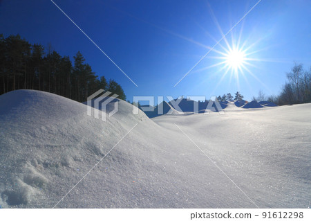 Wonderful winter landscape. Beautiful morning landscape of small snowy hills in winter. Frosty sunny morning. The beauty of winter and the warmth of the sun. 91612298
