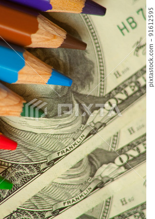 colored pencils and us money in a pink background colored pencils and us money in a pink background 91612595