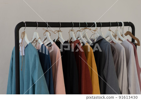 Minimalistic rack with linen colourful clothes on white studio background. 91613430